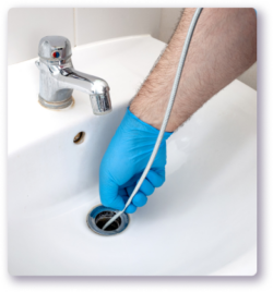 person snaking bathroom sink drain