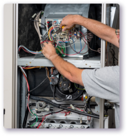 tech working on wiring of furnace